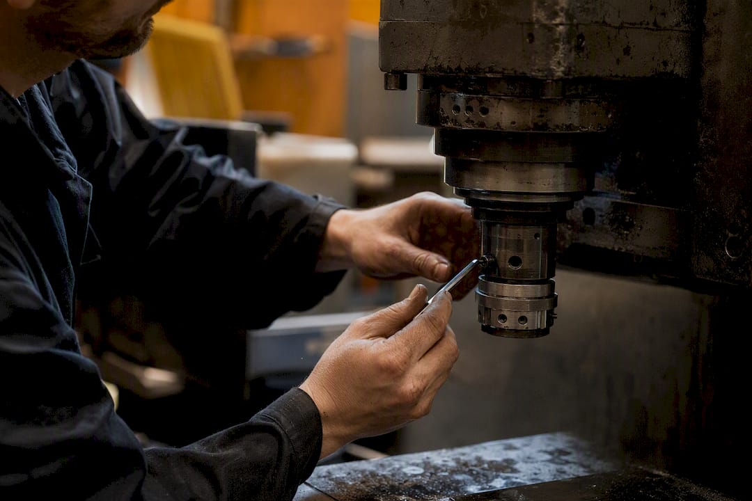 Technician calibrating second-hand CNC machine parts