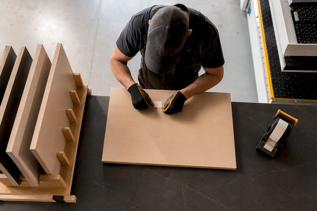 Operator labeling freshly cut cabinet part